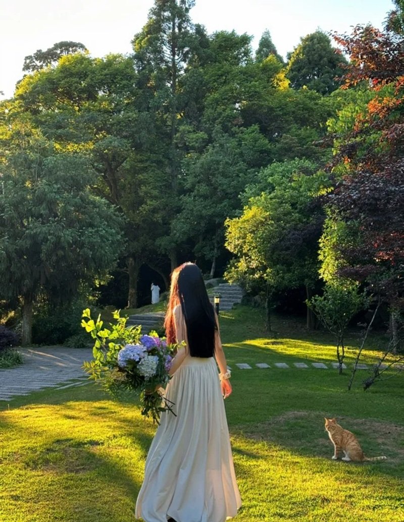 ảnh cô gái quay lưng cầm hoa